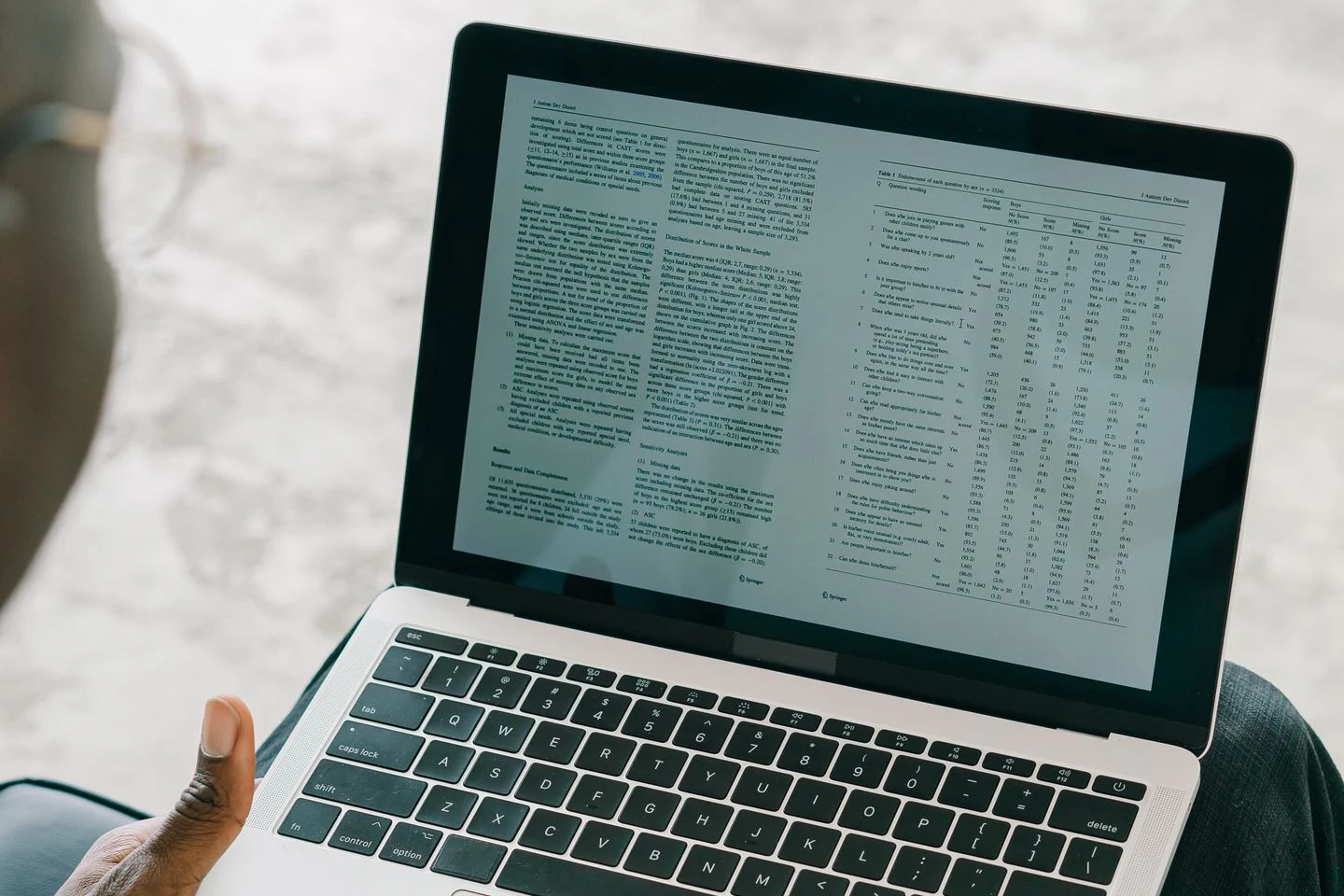 Pessoa conferindo dados tabulares na tela de um notebook